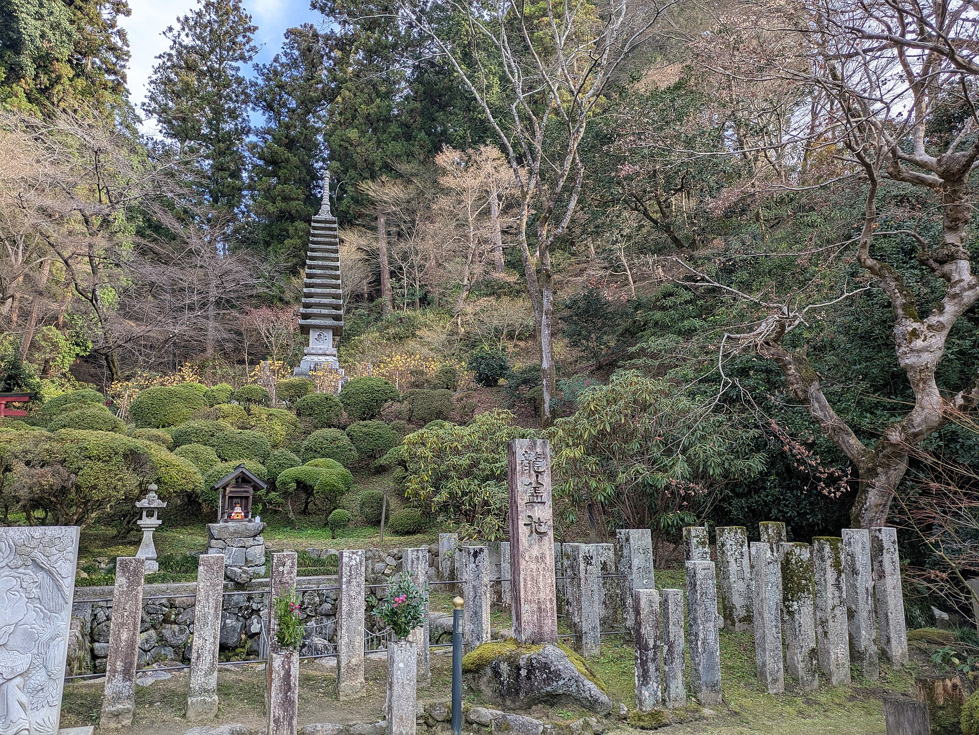 岡寺の境内に立つ「龍蓋池」と刻まれた石柱。根元の岩と、石柱が並ぶ囲いにも目を向けて