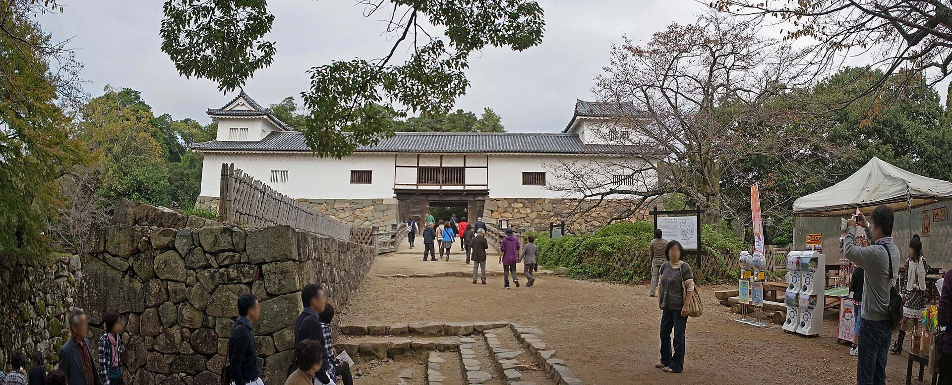 天秤櫓。堀切に架かる橋を渡った先に門が開き、門の左右に白壁の長屋が伸びる