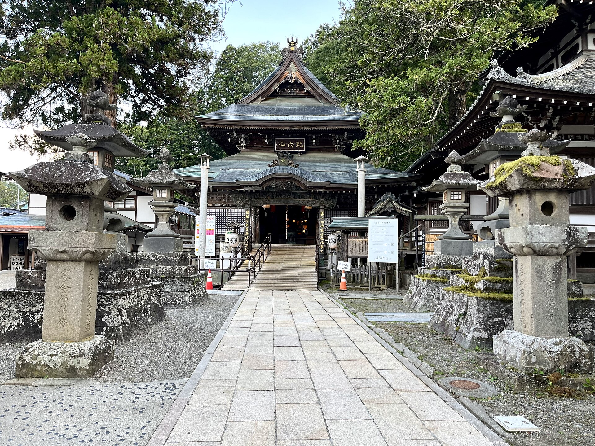 別所温泉の北向観音。石灯籠の並ぶ参道から本堂を正面に見る。軒下に「北向山」の扁額
